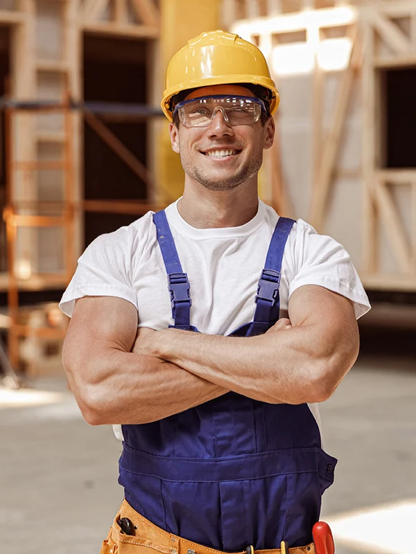 Cheerful Young Man Builder Standing At Constructio 5UEXT86